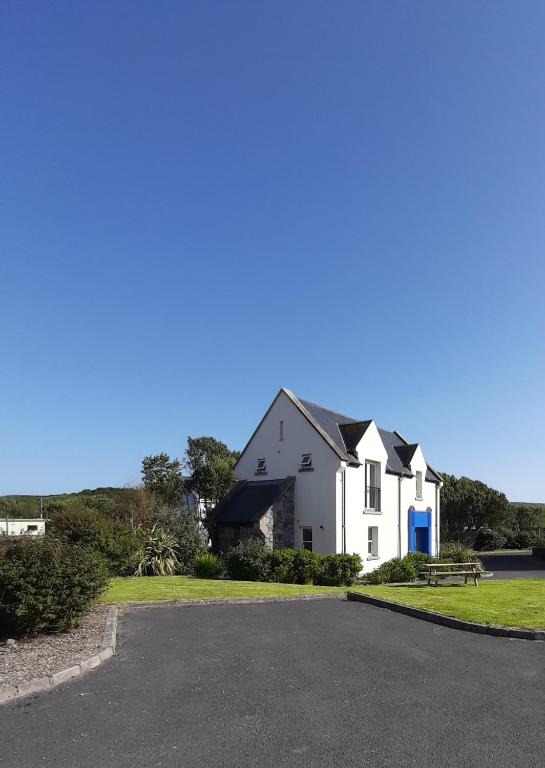 a white house on the side of a road at Doolin Court in Doolin