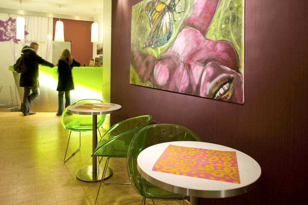 ein paar Tische und Stühle in einem Zimmer mit einem Gemälde in der Unterkunft Dahlia Inn in Prag