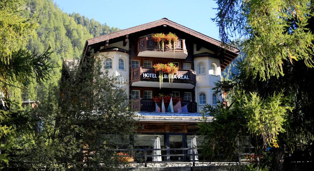 a large building with flowers on the balcony at Albana Real Boutique Hotel - Restaurants & Spa in Zermatt