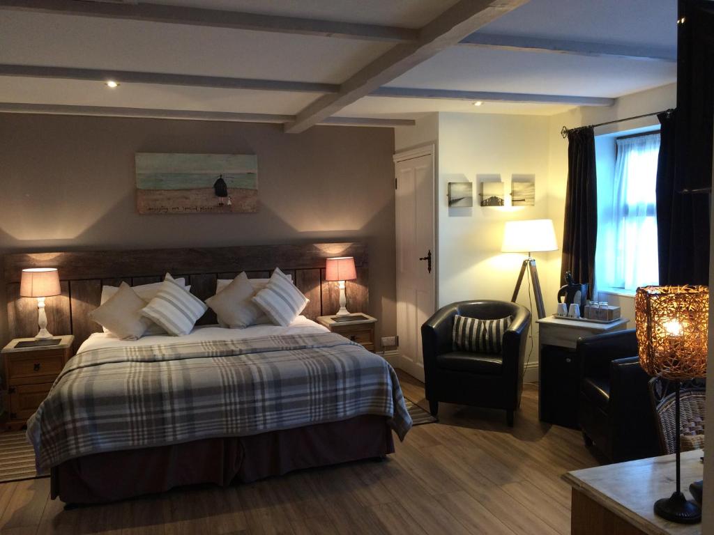 um quarto de hotel com uma cama e uma cadeira em The Cross Guest House em Mablethorpe