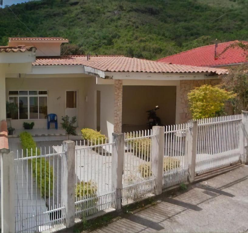 a white fence in front of a house at Casa para temporada in Governador Celso Ramos