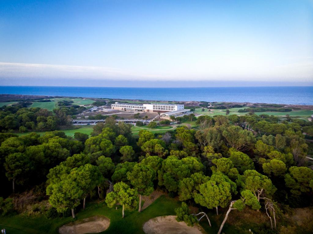 an aerial view of a resort with trees and the ocean at Parador de El Saler in El Saler