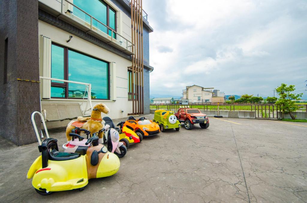 a row of toy cars parked next to a building at 宜人生活溜滑梯親子民宿 Easylife B&amp;B in Dongshan