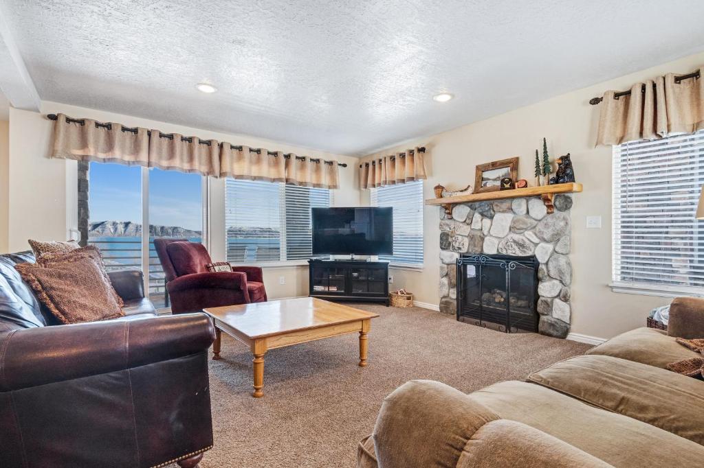 a living room with a couch and a tv and a fireplace at Harbor Village Retreat in Garden City