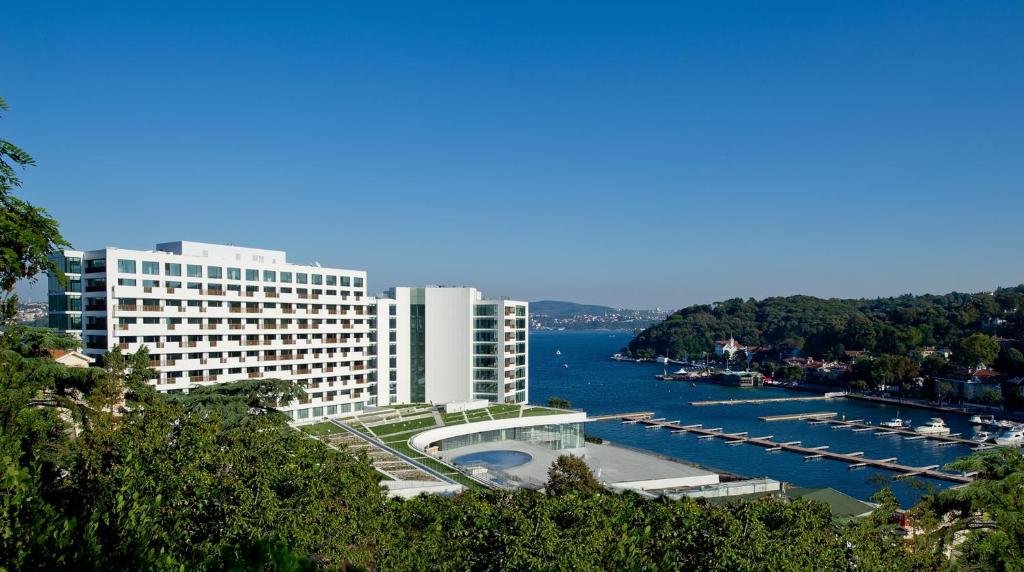 een groot gebouw naast een waterlichaam met boten bij The Grand Tarabya Hotel in Istanbul