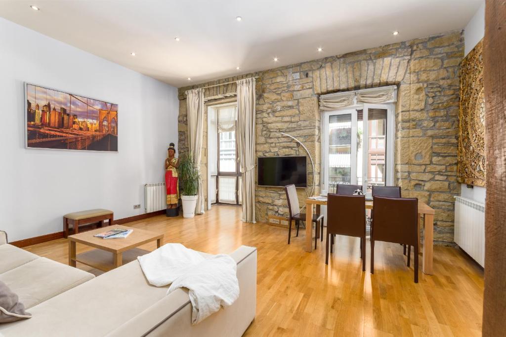 a living room with a table and a stone wall at San Martin 2 - Local Rentss in San Sebastián