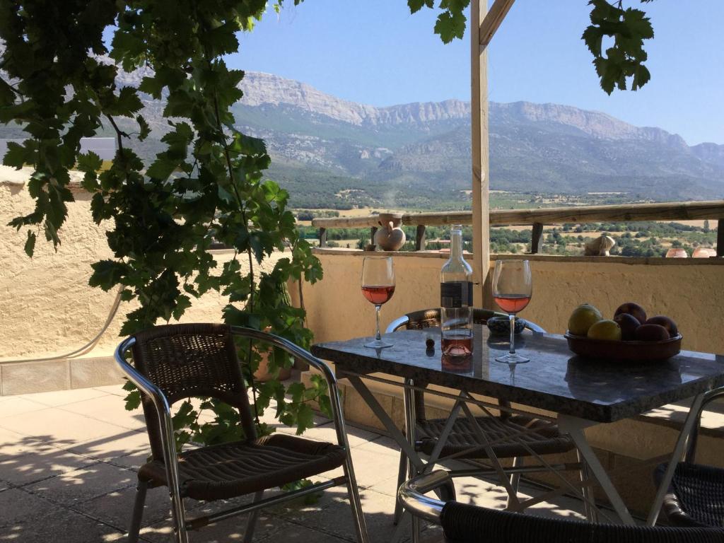 un tavolo con due bicchieri di vino sul balcone di Casa Lucas a Ager