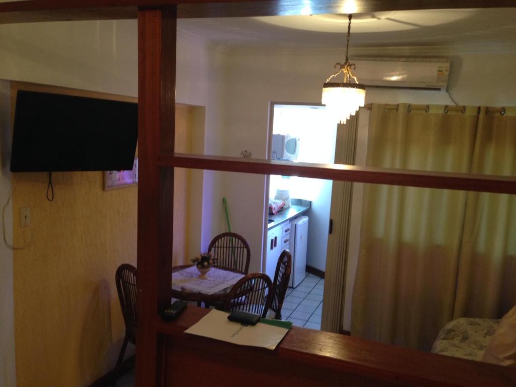 Habitación con escritorio, mesa y espejo. en Bahia Flat, en Salvador