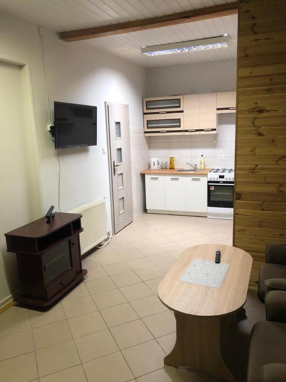 a living room with a table and a kitchen at Apartament dla 4 osób in Dęblin