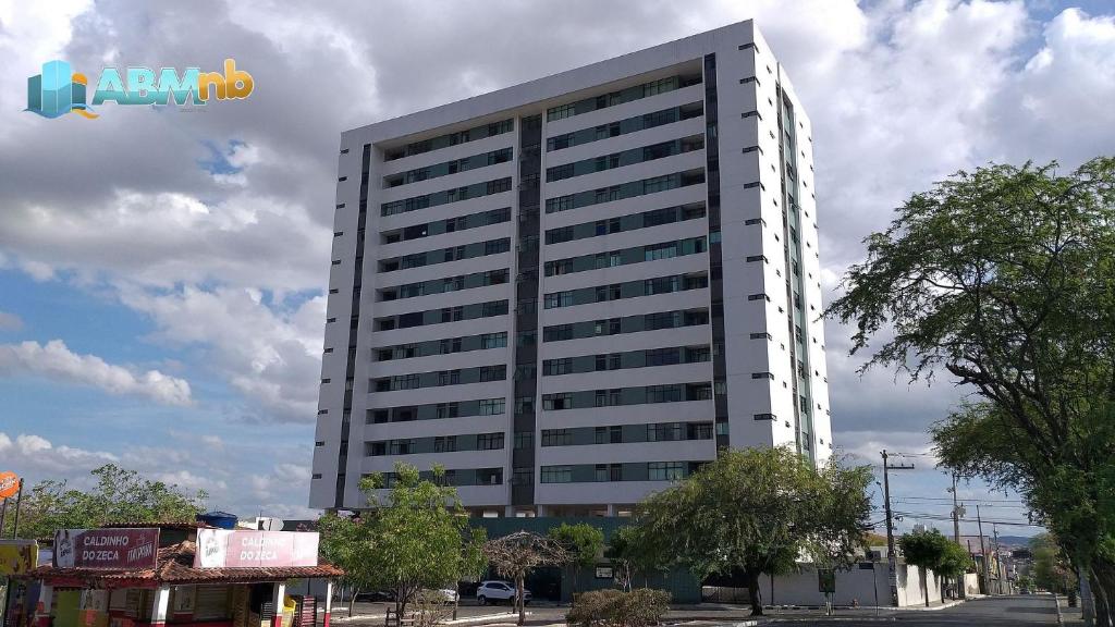 ein hohes weißes Gebäude mit einem Schild an der Seite in der Unterkunft Apto no Universitário Ed. Mr. Teneriff 310 in Caruaru