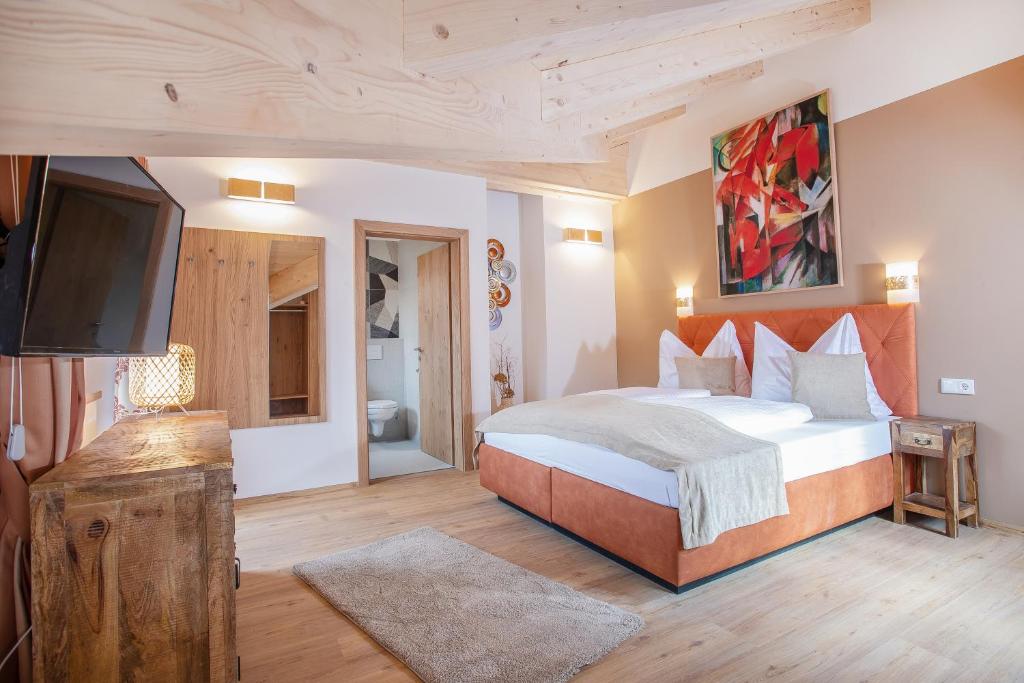 Schlafzimmer mit einem Bett und einem Flachbild-TV in der Unterkunft Gasthof Dorfwirt Sandgruber Ges.m.b.H in Pertisau