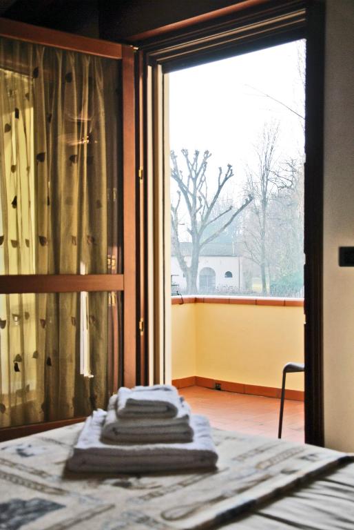 grupa ręczników siedzących na łóżku przed oknem w obiekcie Villa Stefania w mieście Noventa