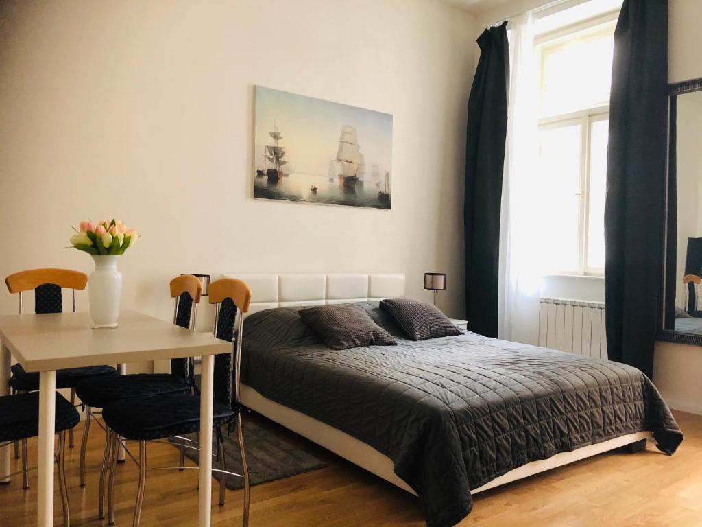 1 dormitorio con 1 cama y 1 mesa con sillas en Modern cozy apartment in central Prague, en Praga