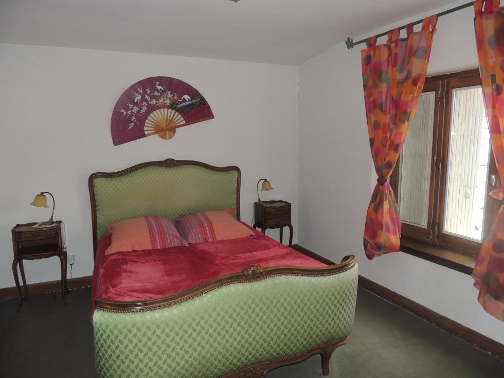 1 dormitorio con 1 cama verde y 2 ventanas en le chant des oiseaux, en Craponne-sur-Arzon