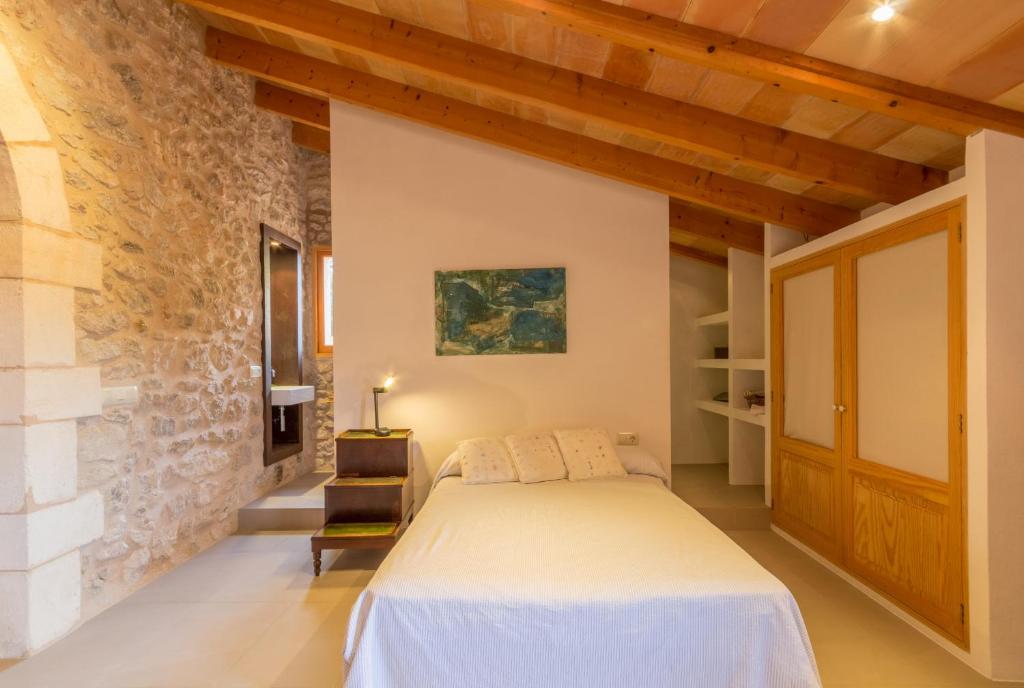 een slaapkamer met een bed en een bakstenen muur bij Son Servera - 306693 in Son Servera