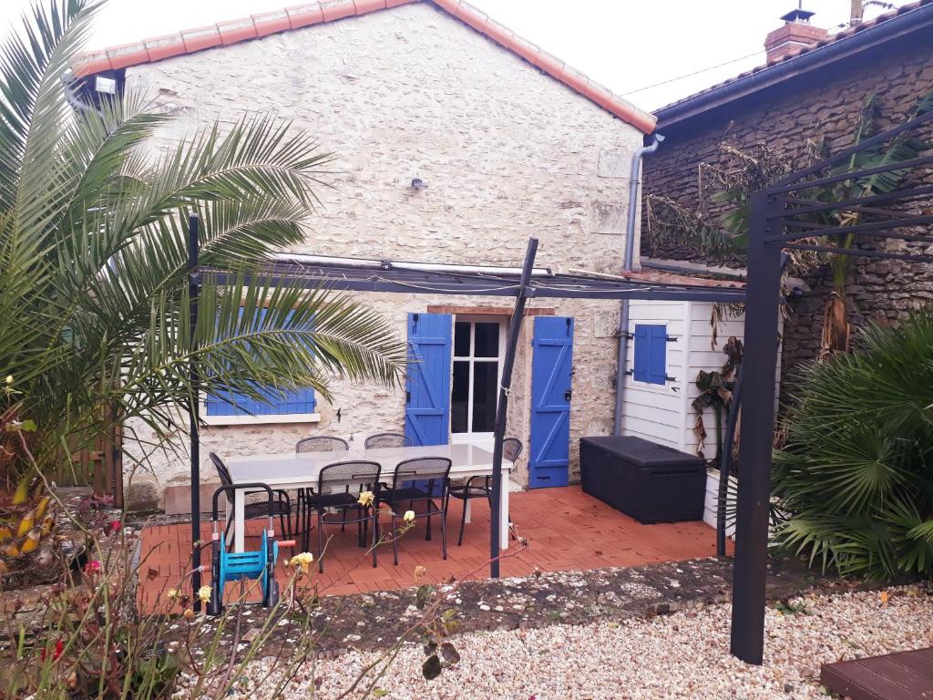 une terrasse avec une table et des chaises devant une maison dans l'établissement Proche Futuroscope - Maison de campagne - La petite Lucie, à Savigny-sous-Faye