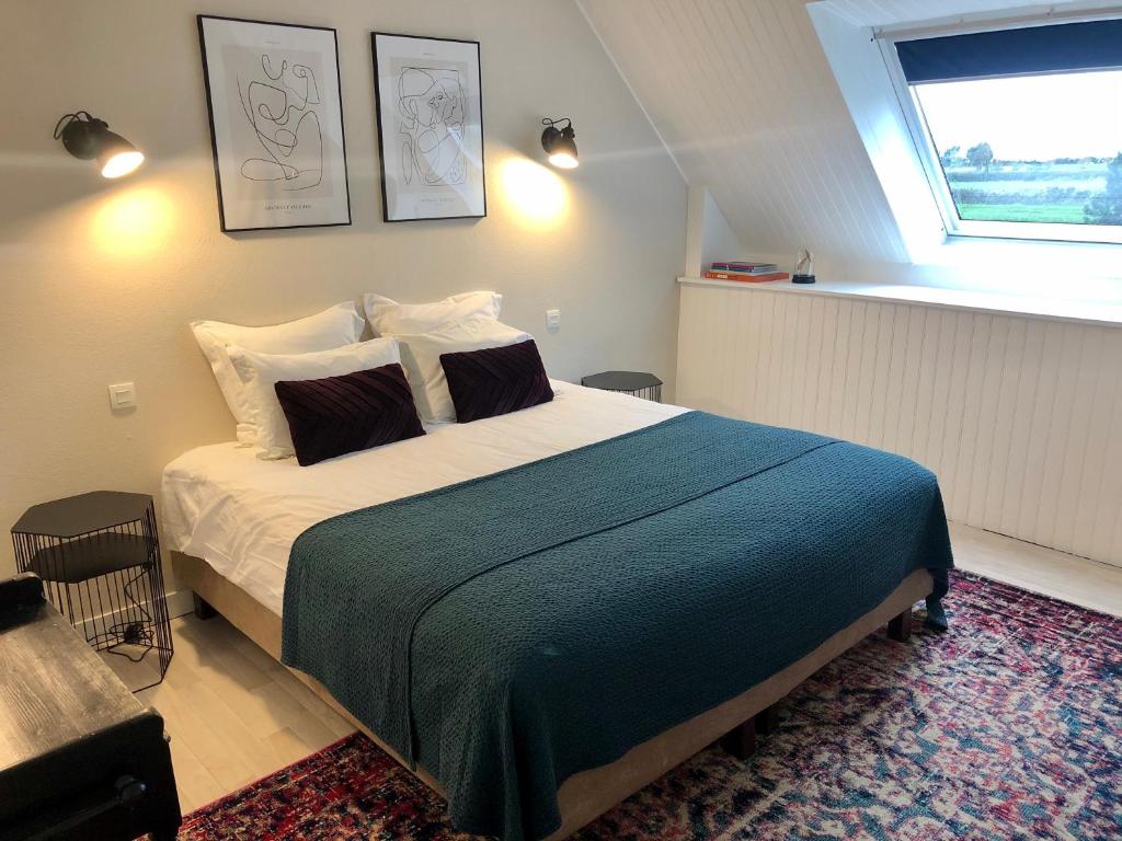 a bedroom with a large bed and a window at La Gervaiserie - 300m de la plage in Réville