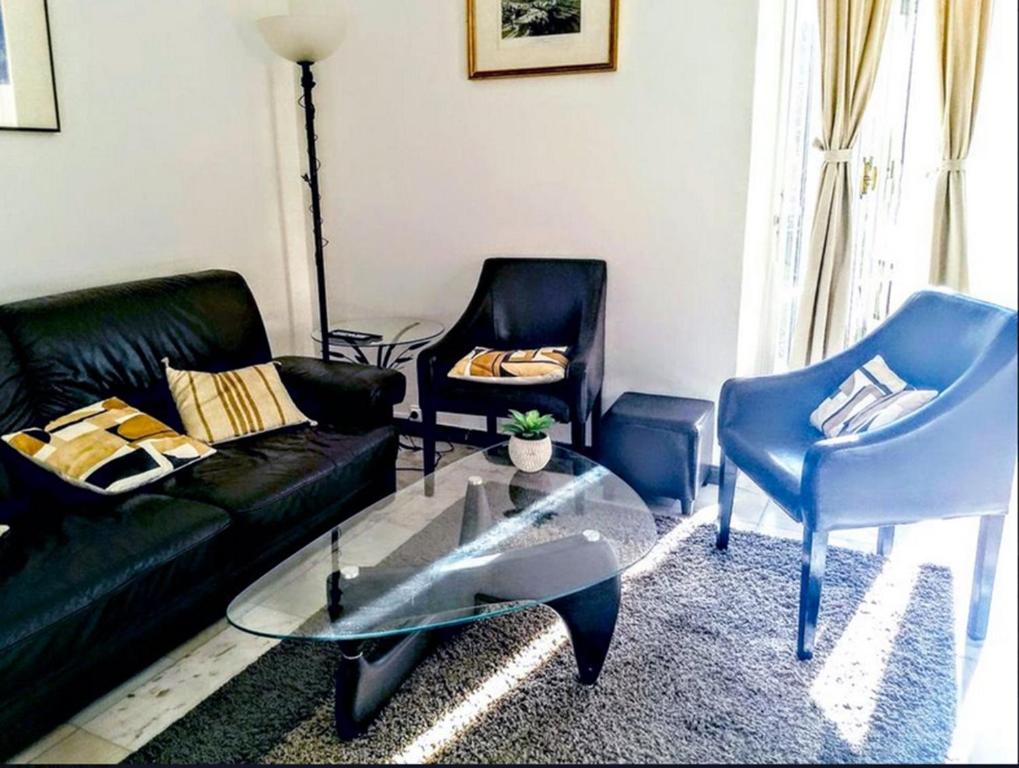 - un salon avec un canapé noir et deux chaises dans l'établissement Le Palladium quartier Tzaréwitch Nice, à Nice