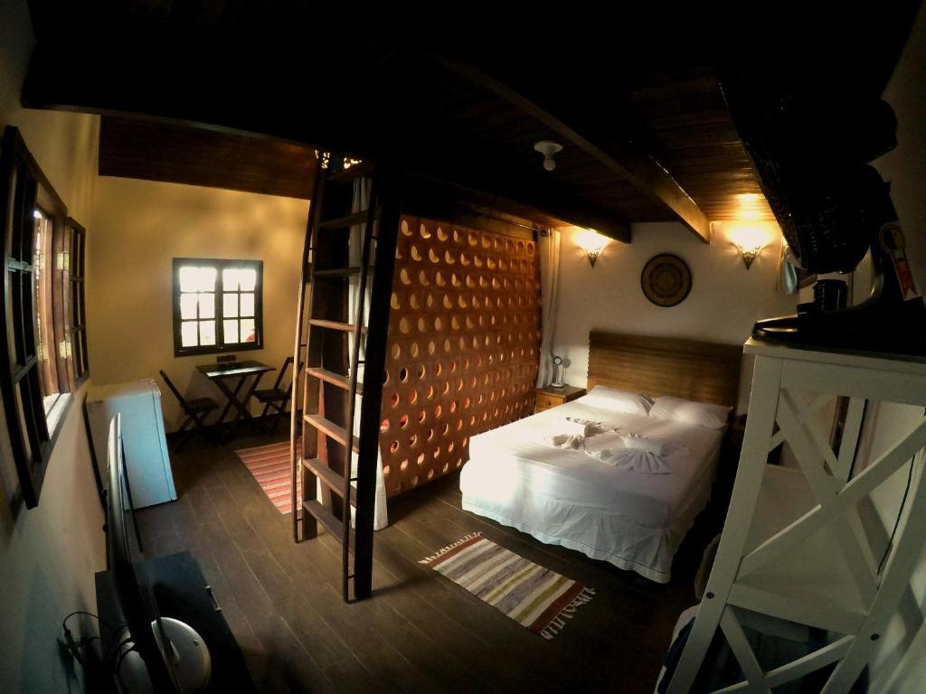 um quarto com uma cama e uma escada em Chalés da Longa em Angra dos Reis