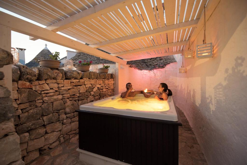 two people sitting in a bath tub in a building at Trulli Holiday Deluxe & Wellness in Alberobello