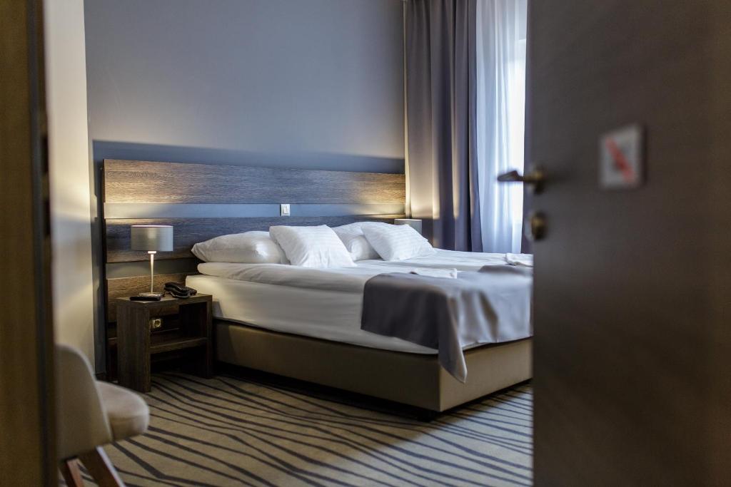 A bed or beds in a room at Öreg Miskolcz Hotel