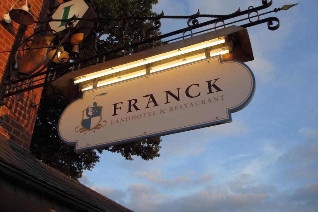ein Schild für ein französisches Restaurant, das an einem Gebäude hängt in der Unterkunft Landhotel Franck Garni in Brietlingen