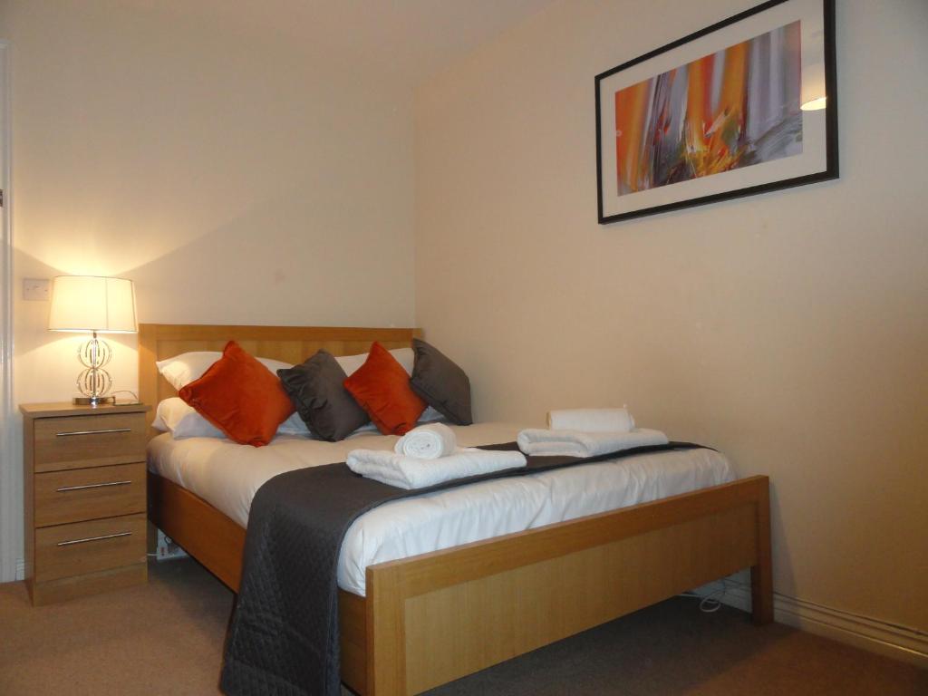 a bedroom with a bed with two towels on it at Redmarley House by Cliftonvalley Apartments in Cheltenham