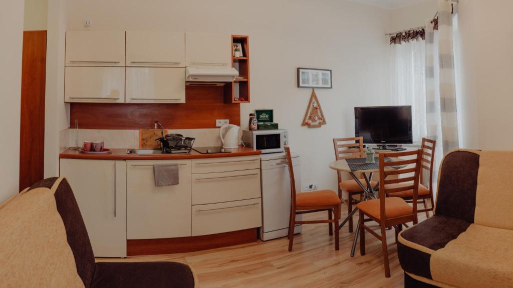 Apartament Zacisze في كارباش: مطبخ مع كونتر وطاولة مع كراسي
