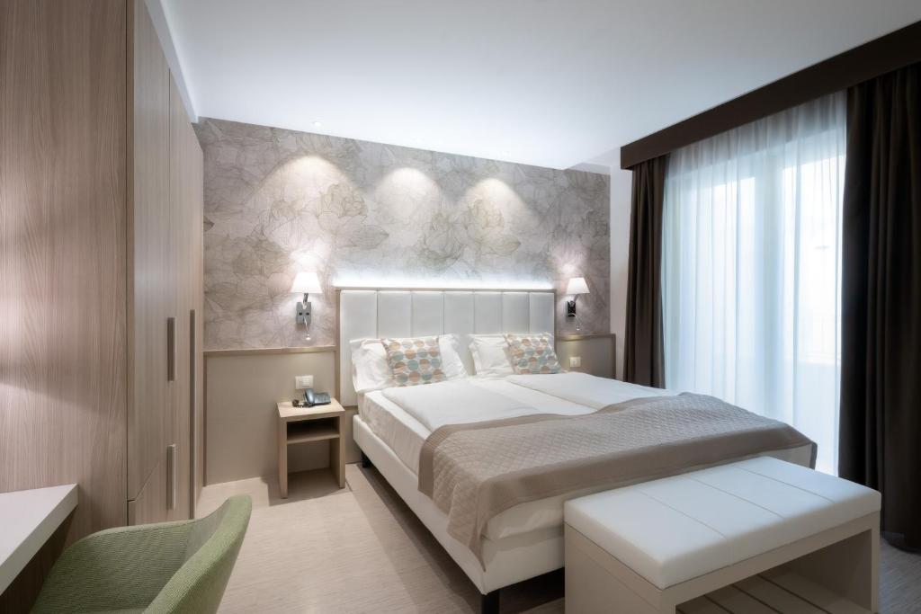 a bedroom with a large bed and a window at International Beach Hotel in Caorle