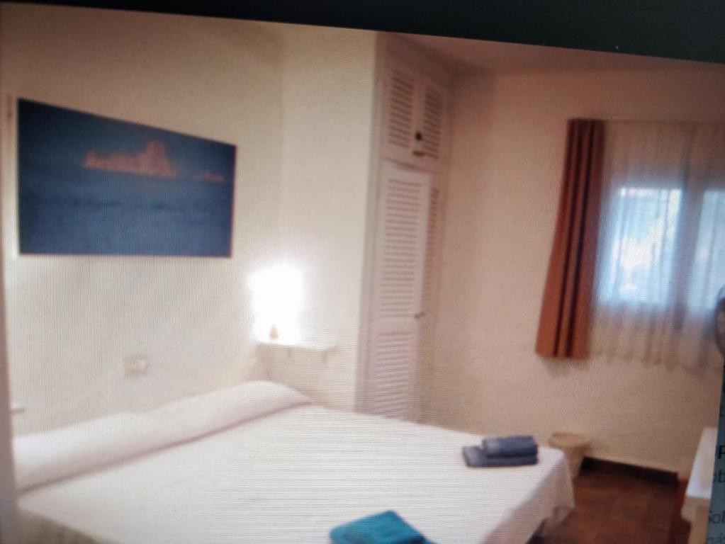 a bedroom with a white bed and a window at Casa Beja in Sant Francesc Xavier