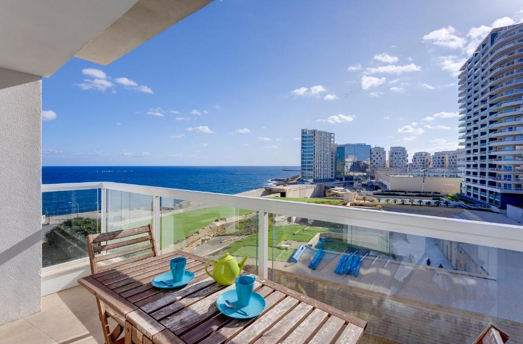 a balcony with a table and a view of the ocean at Apartment with Stunning Seaviews in Sliema