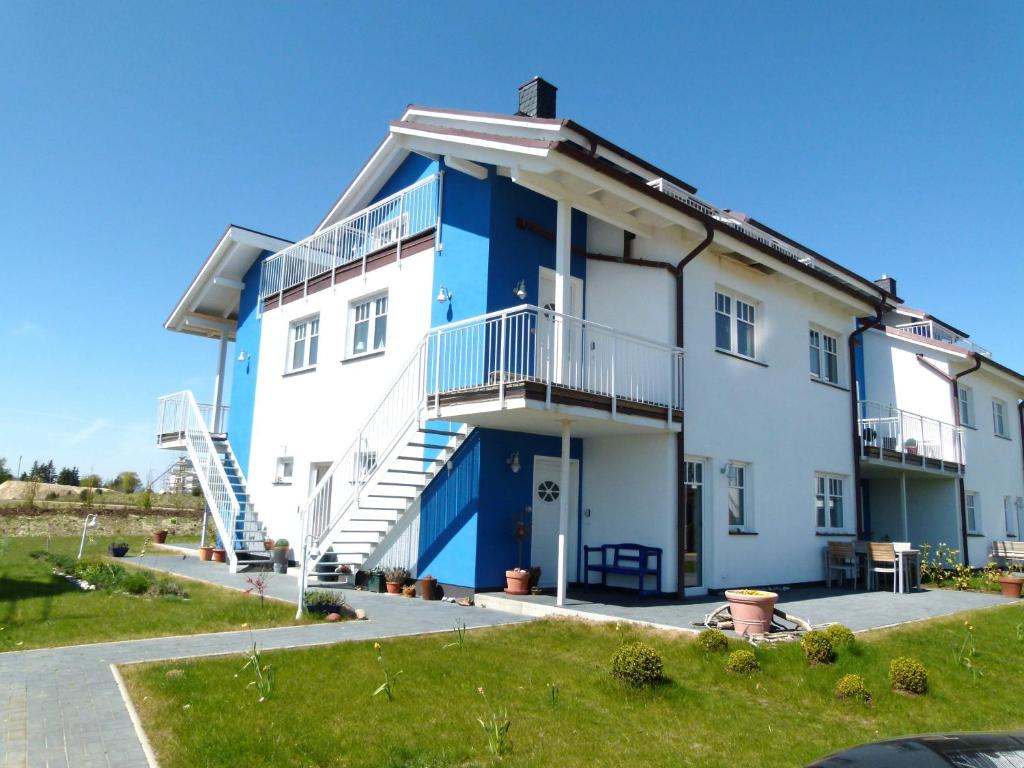 a large white house with a blue facade at "Strand-Gut" in Börgerende-Rethwisch