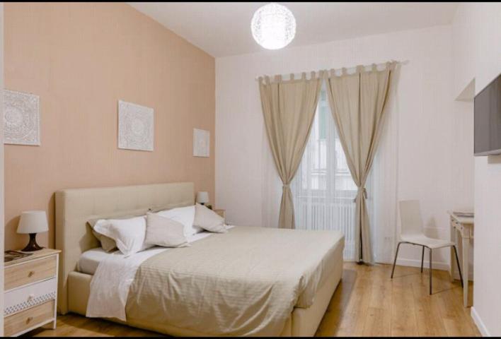 a white bedroom with a bed and a window at Charming 25 Apartment in Rome