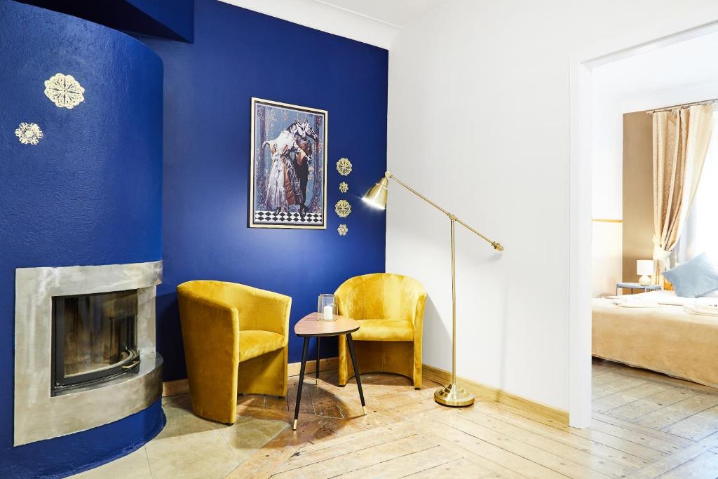 a blue room with two chairs and a fireplace at Prime Location Apartment in Krakow
