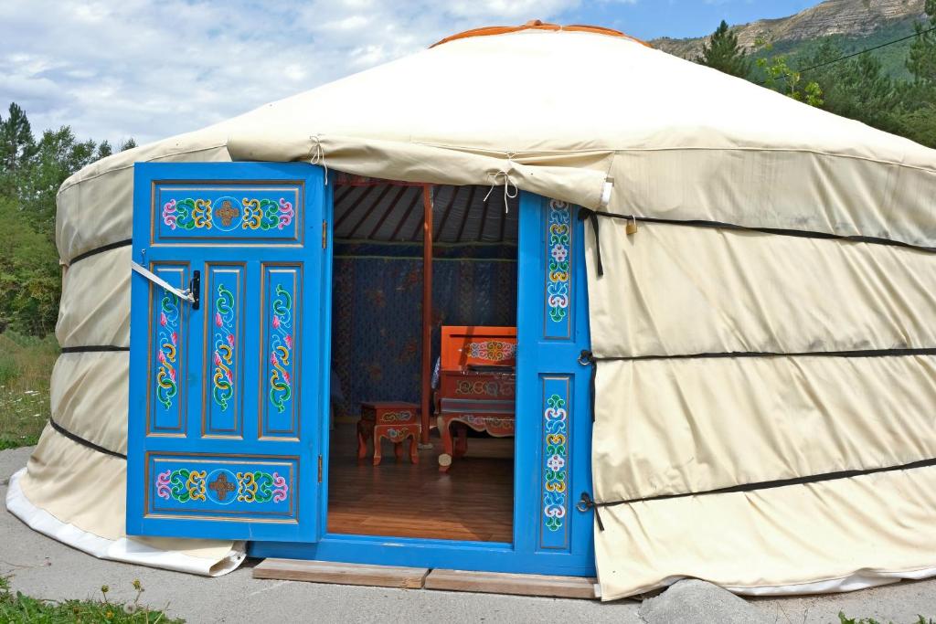 een yurt met een blauwe deur in het midden bij "Verdon Yourtes" Camping à la ferme in Angles