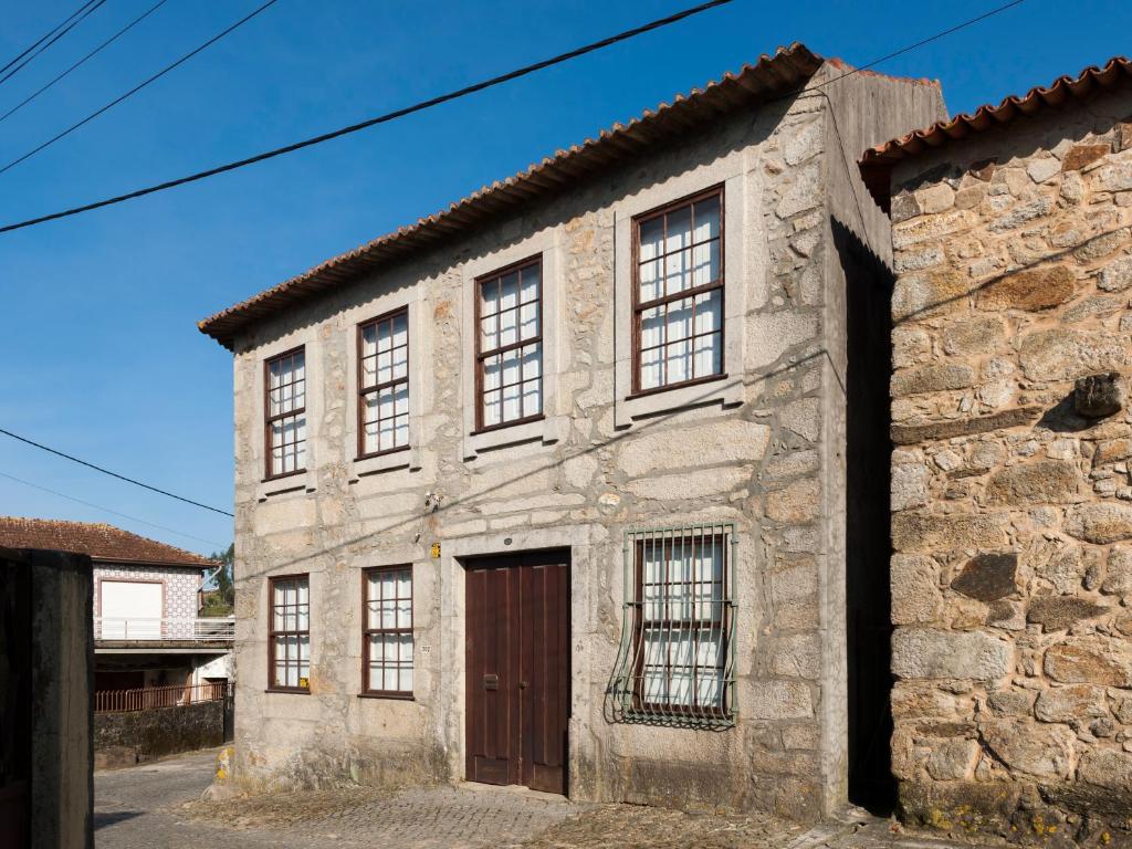 PedrosoにあるCasa do Sobreiroの茶色の扉のある古い石造りの建物