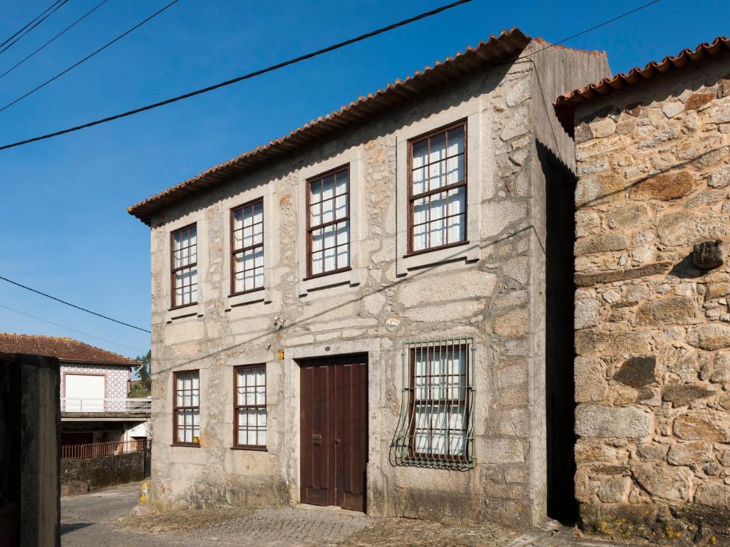 an old stone building with a brown door at Casa do Sobreiro in Pedroso