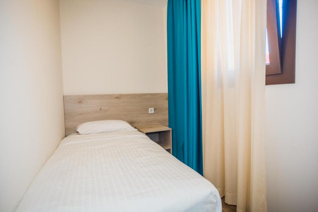 a small bed in a room with blue curtains at Solesperit in Lloret de Mar