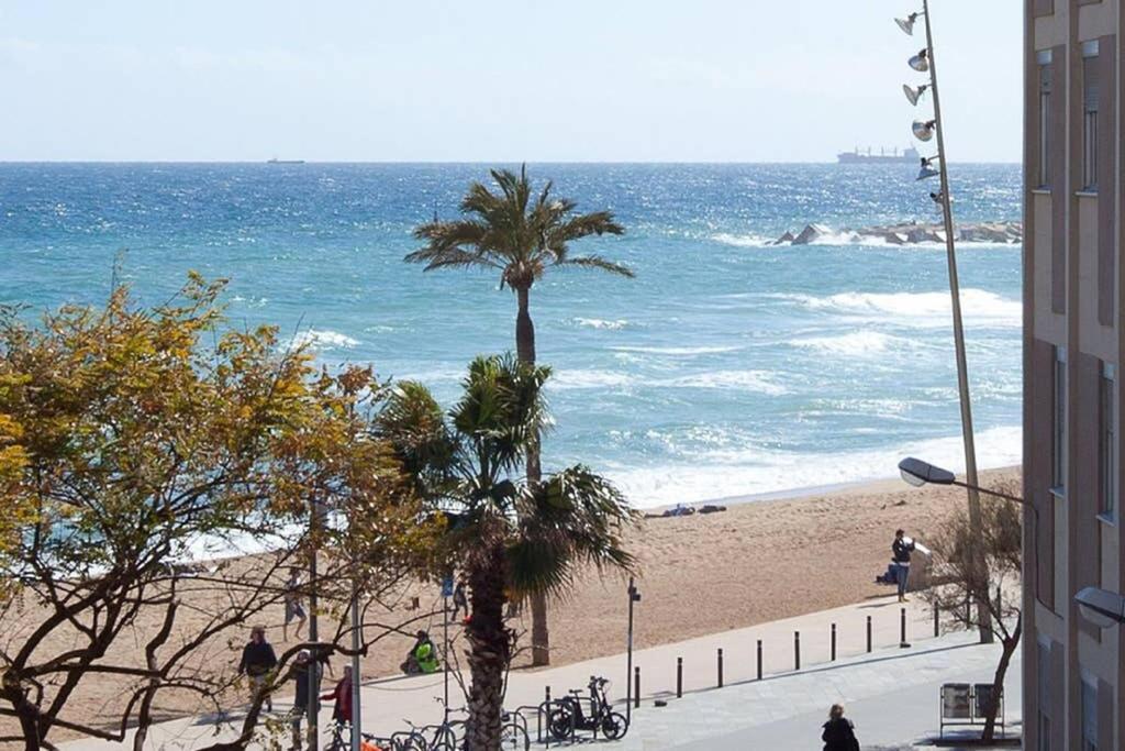 uma vista para uma praia com palmeiras e para o oceano em Easystaybcn2 em Barcelona