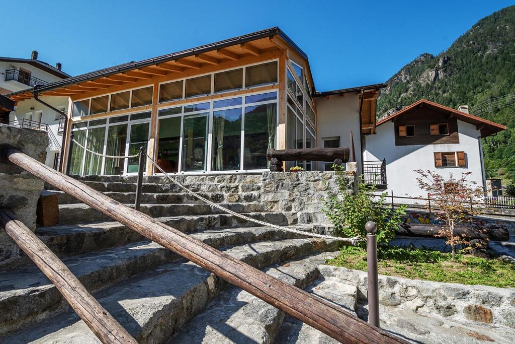 una casa con escaleras frente a un edificio en Hostel - Bormio - Livigno - Santa Caterina - Stelvio, en Sondalo