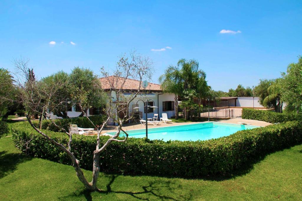 een huis met een zwembad in een tuin bij Villa Sammy in Acquarica del Capo