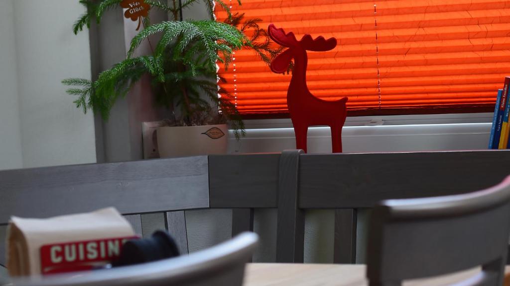 a red moose statue sitting on top of a table at Haus Wopke in Borkum