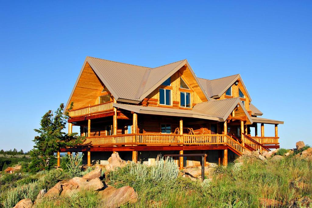 a large wooden house on top of a hill at Luxe Lodge in the Tetons for Large Group Retreats! in Newdale