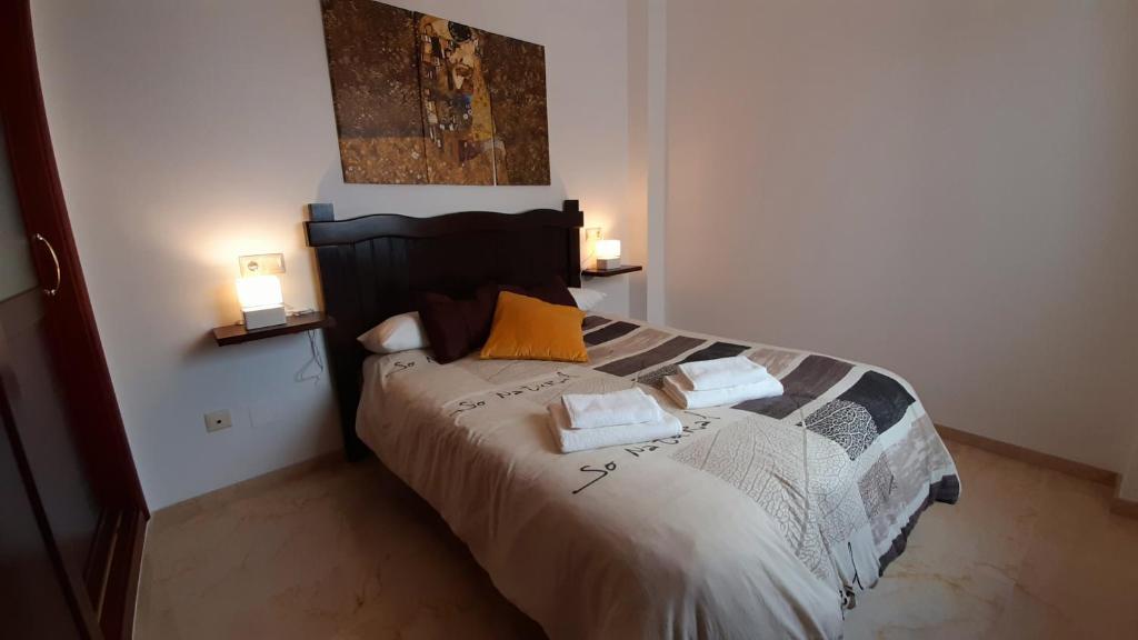una camera con un letto con due cuscini sopra di Apartamento cómodo y acogedor en el centro con WiFi a Ronda