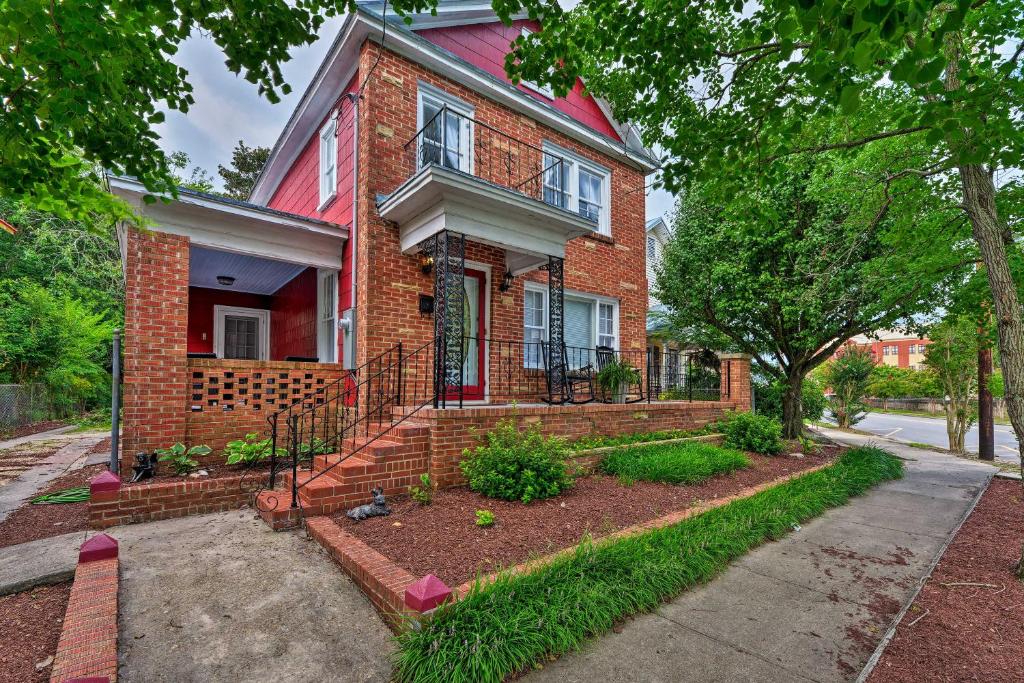 une maison en briques rouges avec un jardin en face de celle-ci dans l'établissement New Bern Home with Yard, Grill and Walkable Location, à New Bern