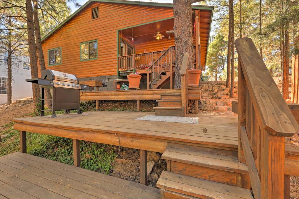 a log cabin with a grill on a wooden deck at Rustic Cabin with Deck about 4 Mi to Old Town Flagstaff! in Flagstaff