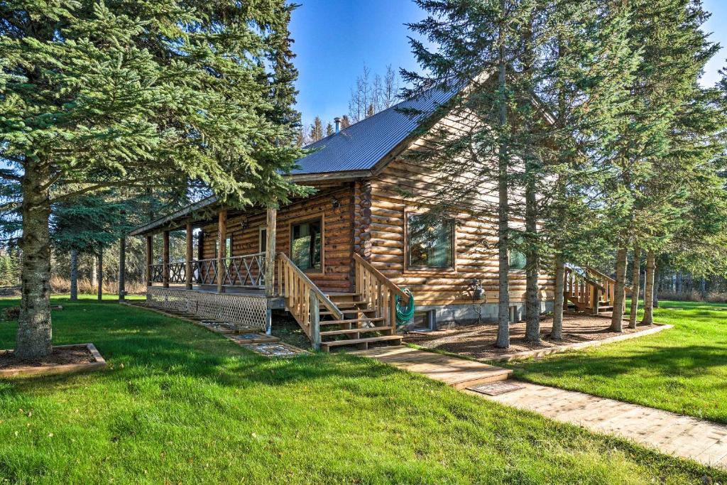 a log cabin with a large porch and trees at Cabin on Kenai Peninsula Family and Group Friendly! in Kenai