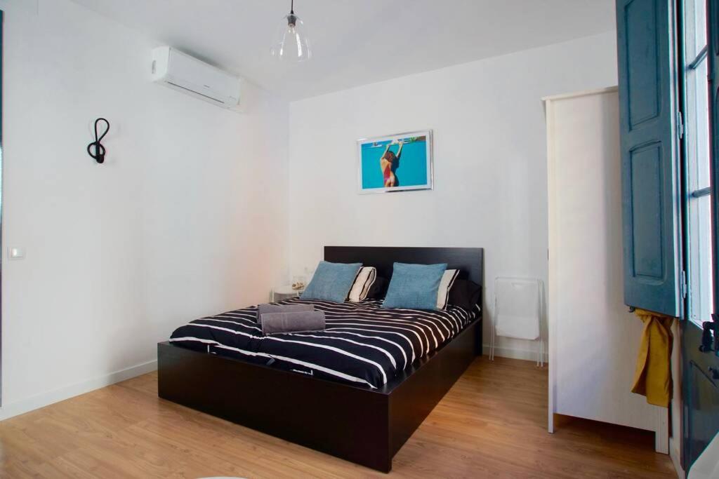 Un dormitorio con una cama con almohadas azules. en LOVELY FLAT FIRA MWC, en Hospitalet de Llobregat