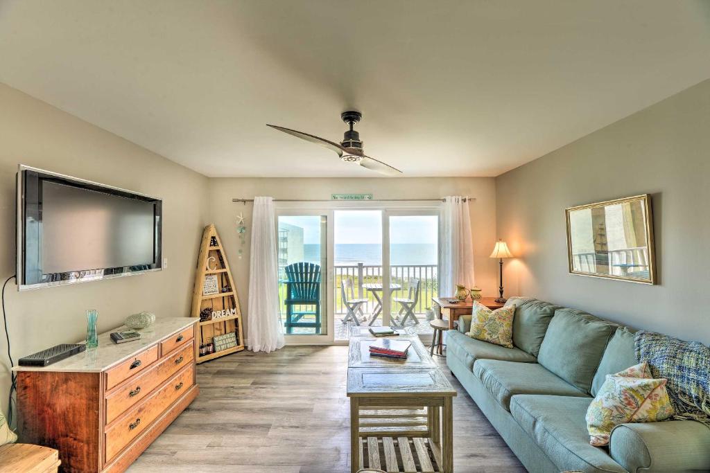 een woonkamer met een bank en een televisie bij Airy Oceanfront Condo Beach Views and Pool Access! in North Topsail Beach