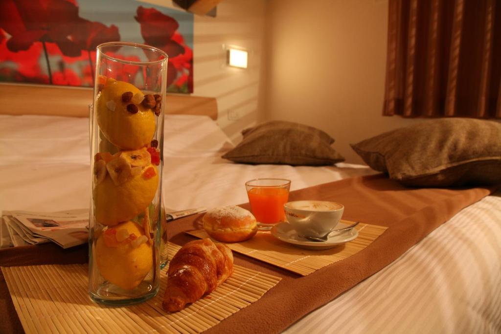 a table with a vase with food and drinks on a bed at Residence Ilario Suite Hotel in Riccione